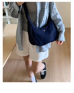 Détail du sac hobo en nylon bleu marine avec logo minimaliste et bandoulière
