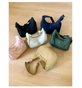 Vue à plat de sacs croissant en nylon en six couleurs avec logos en métal rond