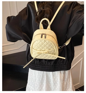 Sac à dos matelassé beige avec nœud, porté par un mannequin de dos en vue détaillée