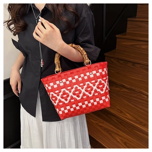 Détail du sac tressé à damier rouge et blanc avec anses en bambou et anneaux en métal