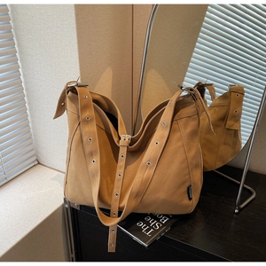 Detail of ginger canvas hobo bag with metal eyelets on strap and brand side label