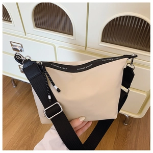 Detail of adjustable black strap and silver buckle on the cream minimalist nylon bag