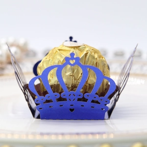 Detail of royal blue laser-cut crown candy box with intricate lace patterns and metallic finish