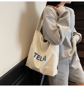 Dettaglio borsa tote in tela beige con ricamo blu TELN! e tracolla larga