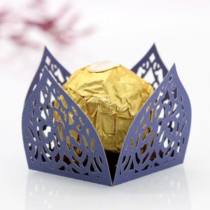 Macro detail of laser-cut purple vine lace candy box holding a gold foil chocolate