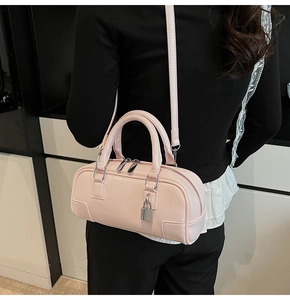 Detail of light pink patent leather Boston bag featuring a silver metal padlock charm
