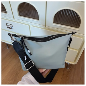 Detail of the durable nylon crossbody bag with logo strap and silver hardware accents