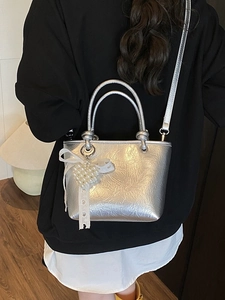 Silver metallic bucket bag with pleated texture, pearl heart charm and lace bow detail