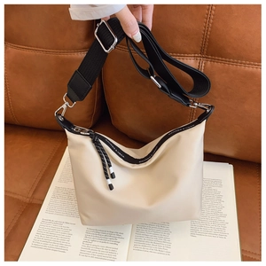 Detail of CAHRES & HEKA cream dumpling bag with adjustable black strap and rope detail