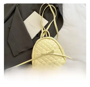 Détail du sac à dos jaune matelassé avec nœud élégant et fines bretelles en similicuir chic
