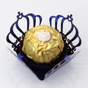 Detail of laser-cut crown candy box in deep blue metallic paper for party decoration
