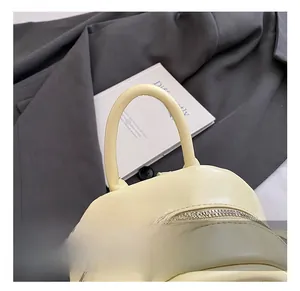 Détail du sac à dos matelassé jaune avec double fermeture éclair sur un manteau en laine