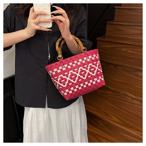Détail du sac cabas tissé main avec motifs rose rouge et poignées en bambou naturel