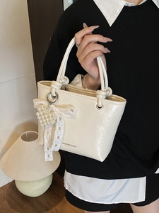 Chic cream white bucket bag with lace bow and pearl heart charm, stylish top handle