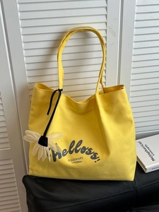 Large yellow canvas tote bag with daisy pendant and stylish shoulder strap for women