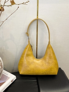 Yellow crocodile pattern hobo shoulder bag with adjustable silver buckle on display