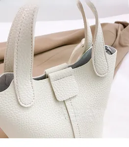 Detailed close-up of cream white lychee pattern leather handbag with refined stitching