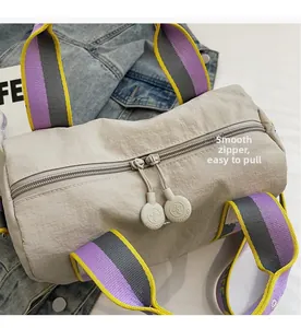 Dettaglio della doppia zip scorrevole e dei manici intrecciati colorati della borsa
