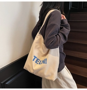 Dettaglio del ricamo blu TELN! 3D su una grande borsa tote in tela color bianco sporco