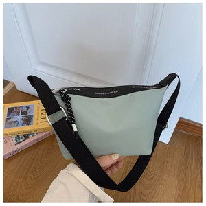 Close-up of mint green dumpling bag with CAHRES & HEKA branded webbing and wide black strap