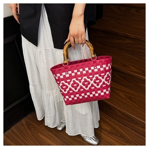 Détail du sac à main tressé à carreaux rose et blanc avec anses aspect bambou