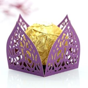 Macro shot of purple laser-cut candy box with elegant vine patterns and gold foil chocolate