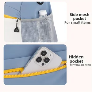 Detail of blue fitness bag featuring a mesh side pocket for water bottles and hidden zipper pocket