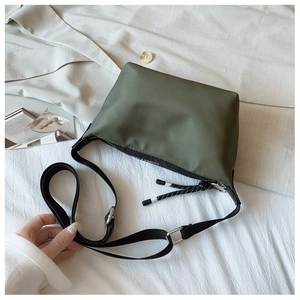 Detail of army green nylon dumpling bag with woven zipper puller and adjustable strap
