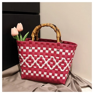 Gros plan d'un sac cabas tissé main avec motif rose et détails de poignée en bambou