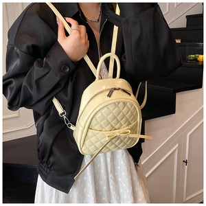Détail du motif matelassé et du nœud sur le mini sac à dos seau jaune pastel