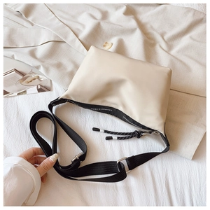 Detail of off-white nylon dumpling bag with adjustable strap and designer ribbon accent