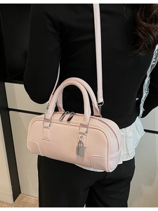 Pink patent leather Boston handbag with silver padlock shown on a female model
