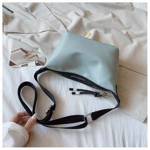 Detail of mint green nylon dumpling bag featuring a knot zipper and adjustable strap