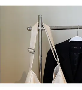 Gros plan du sac à bandoulière crème avec sangle réglable et boucle en métal argenté