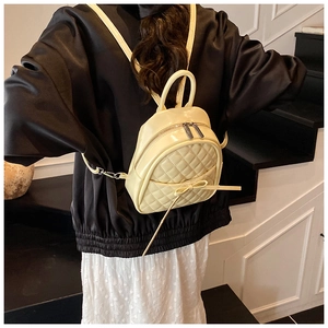 Détail du sac à dos matelassé beige avec nœud décoratif et fines bretelles sur modèle