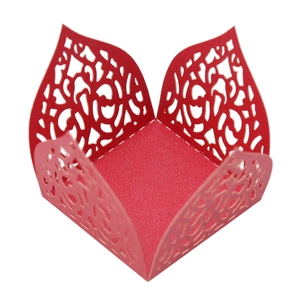 Detailed laser-cut hollow floral pattern on a red paper cupcake wrapper for party favors