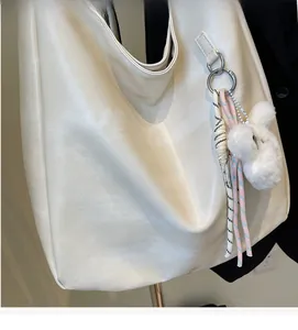 Détail de la texture du sac bandoulière crème avec pendentif lapin en peluche