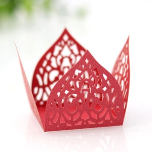 Macro view of laser-cut red paper candy box with intricate lace patterns for parties