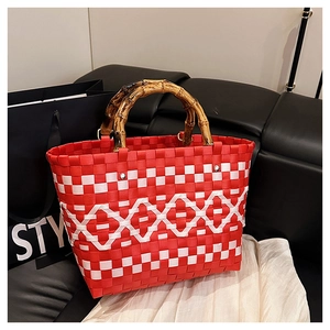 Détail du sac tissé géométrique rouge et blanc avec anses en bambou et rivets en métal