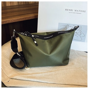 Detailed view of army green nylon crossbody bag with adjustable strap and brand logo tape