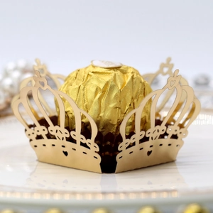 Macro detail of laser-cut gold crown chocolate wrapper with heart-shaped hollow patterns