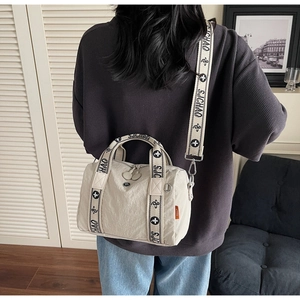 Dettaglio della borsa in nylon crema con tracolla regolabile con motivo SJCHAO