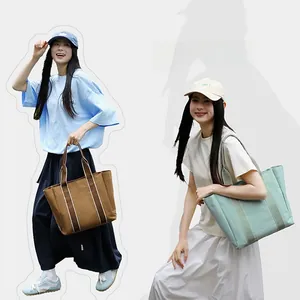 Detail showing high-capacity canvas tote bags in brown and mint green with dual straps