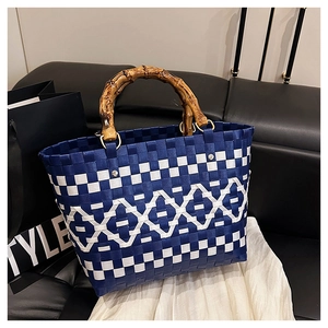 Détail d'un sac cabas tissé à carreaux bleu et blanc avec poignées en bambou naturel