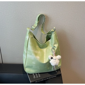 Détail du sac hobo vert avec texture PU souple et charmant ours en peluche blanc attaché