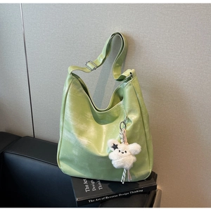 Détail du sac fourre-tout vert clair avec pendentif lapin en peluche et boucle argent