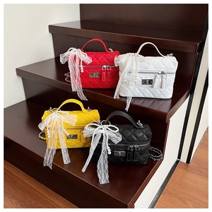 Détails de quatre sacs matelassés en rouge, blanc, jaune, noir avec nœuds en dentelle