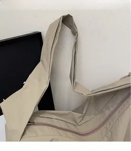Détail de la large bandoulière en nylon et de la fermeture éclair du sac bandoulière