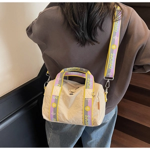 Dettaglio della tracolla jacquard colorata e del logo sulla borsa in nylon beige