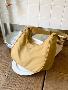 Sac bandoulière demi-lune en nylon jaune moutarde avec sangle réglable sur bois